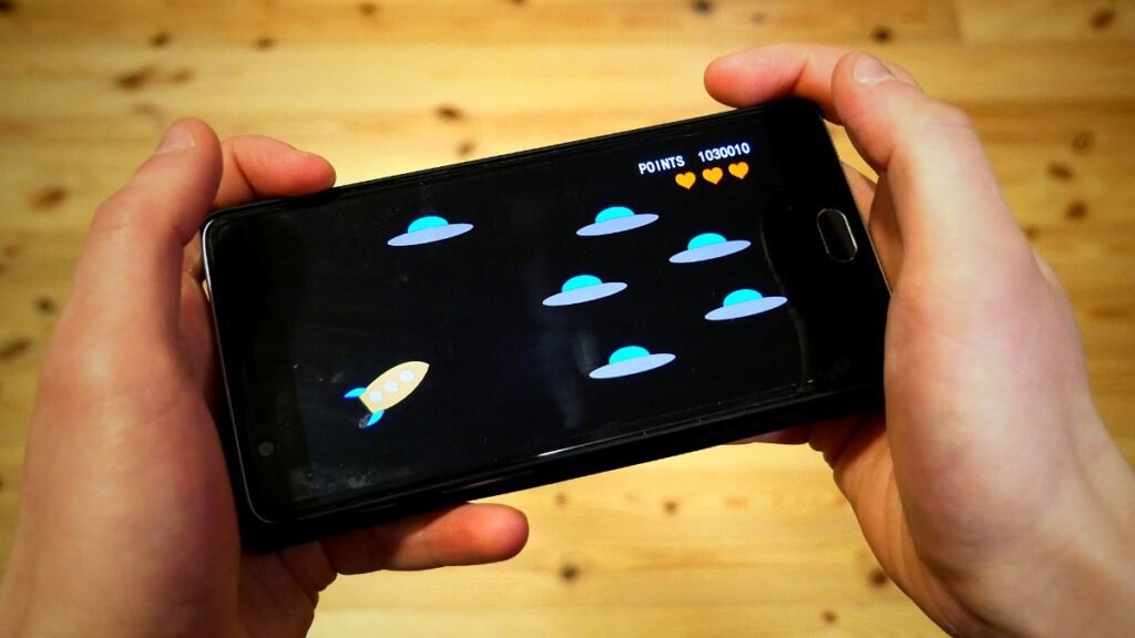 Hands holding a smartphone while playing a mobile game